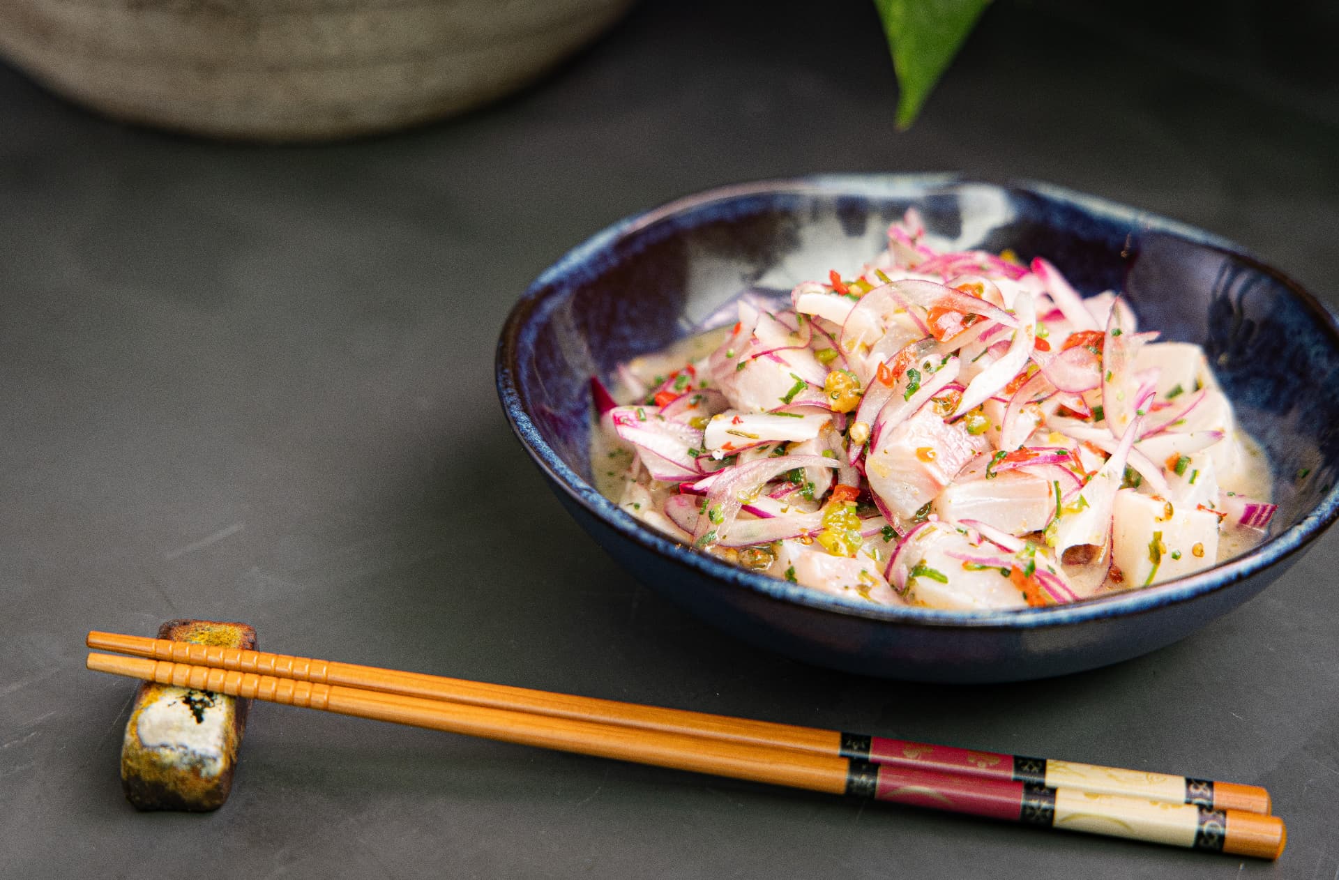 Ceviche de peixe branco com cebola roxa, pimenta e leite de tigre em bowl azul do SAIKO